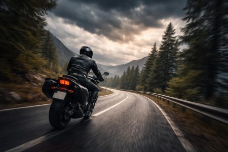 motard-route-sinueuse-montagne-nuages